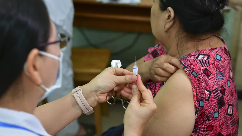 Bác sĩ tiêm vaccine cúm cho người cao tuổi tại Trạm y tế phường An Phú Đông