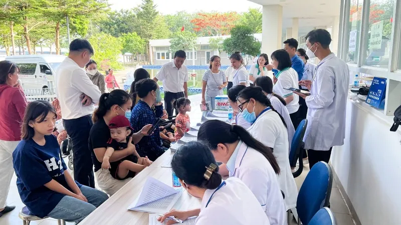 Nhân viên y tế tiếp đón, hướng dẫn và hỗ trợ làm thủ tục khám cho trẻ