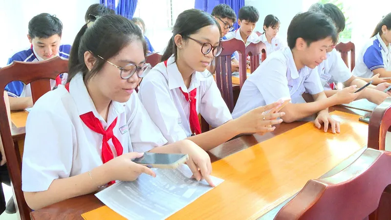 Các em học sinh THCS thực hiện các thủ tục trên thiết bị điện thoại thông minh