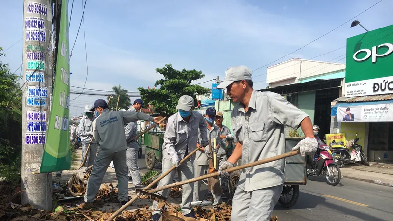 Người dân quét dọn sau khi tham dự hưởng ứng Tuần lễ Quốc gia nước sạch và vệ sinh môi trường