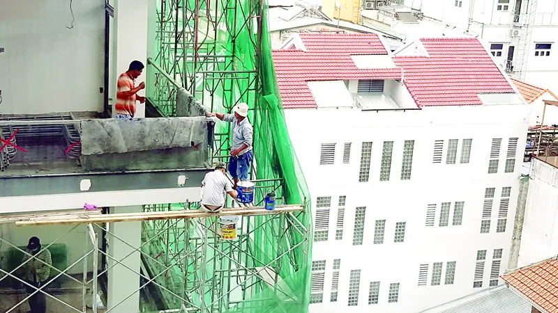 Công nhân làm việc như làm xiếc tại một công trình xây dựng cao tầng ở quận 3, TPHCM. Ảnh: KHẮC HÀO
