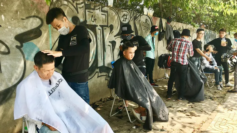 Tiệm cắt tóc miễn phí trên vỉa hè đường Phạm Văn Đồng
