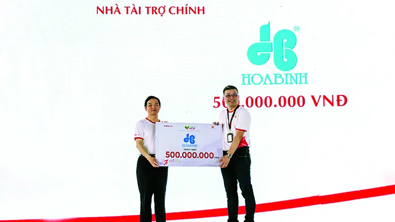 Ông Lê Viết Hải, CT. HĐQT kiêm TGĐ Hòa Bình (trái) trao tặng 500 triệu đồng cho chương trình