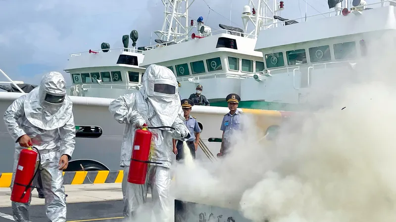 Cán bộ, nhân viên Chi đội Kiểm ngư số 2 tham gia chữa cháy bằng bình cứu hỏa. Ảnh: MẠNH THẮNG
