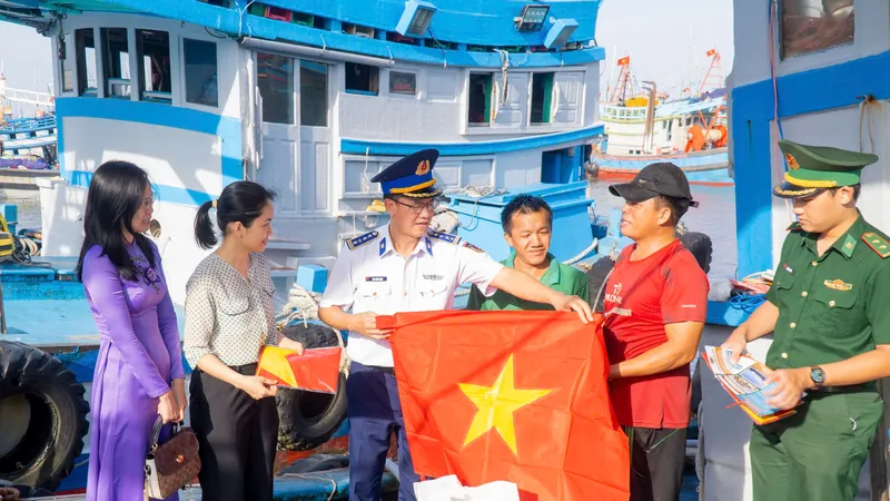 Đại tá Cao Xuân Quận, Phó Chính ủy Vùng Cảnh sát biển 3 cùng đại diện các lực lượng vũ trang đóng chân trên địa bàn, cấp ủy, chính quyền địa phương trao tặng cờ Tổ quốc quốc và các nhu yếu phẩm động viên ngư dân Bà Rịa - Vũng Tàu. Ảnh: MẠNH THẮNG
