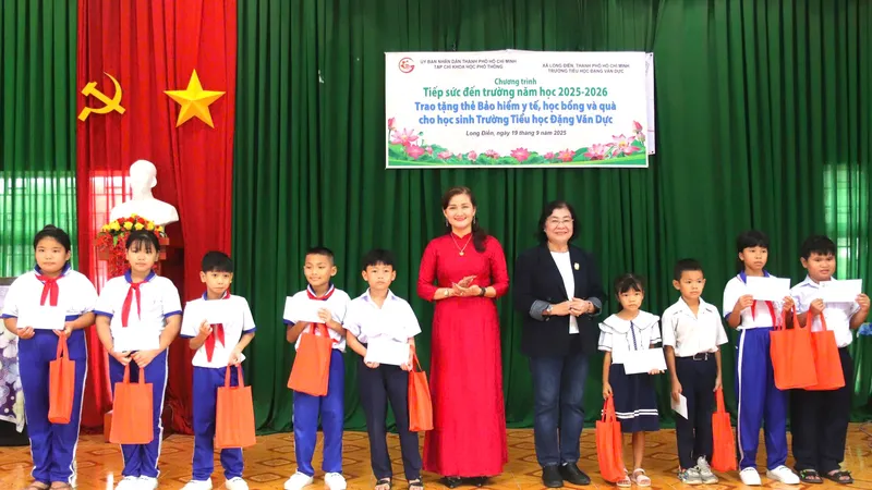 Nhà báo Bùi Hương, Phó Tổng Biên tập Phụ trách Tạp chí Khoa học phổ thông và lãnh đạo nhà trường trao thẻ bảo hiểm cho học sinh