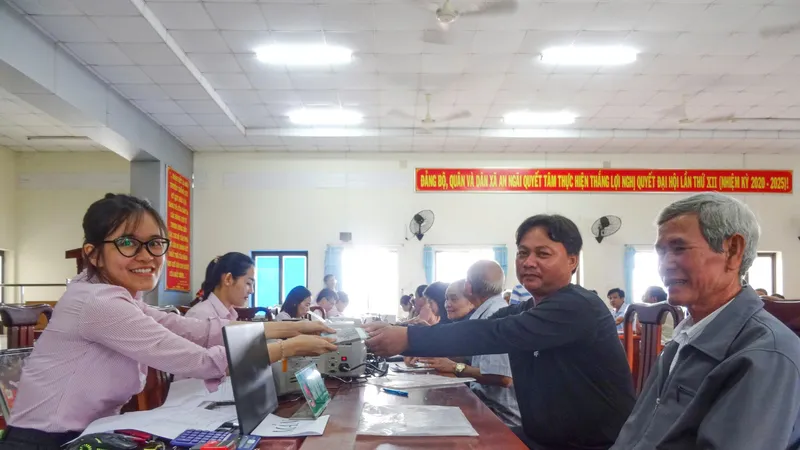 Nhân viên Phòng Giao dịch NHCSXH Bà Rịa - Vũng Tàu giải ngân vốn tín dụng tại xã Long Điền