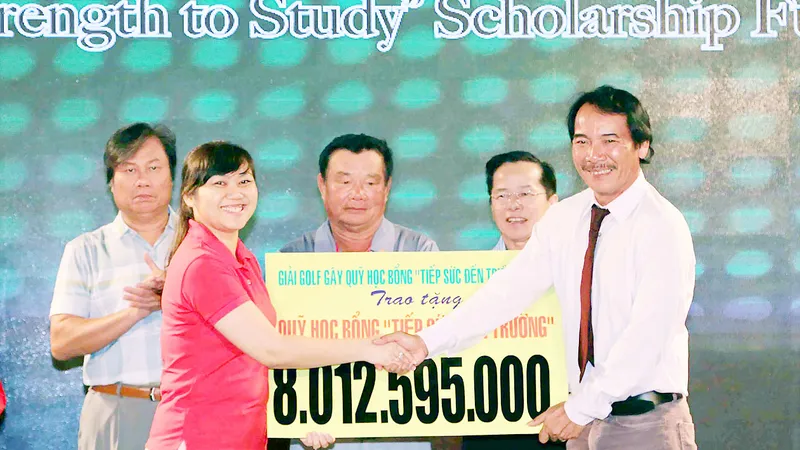 Ông Lê Quốc Phong (bìa phải) trao số tiền thu được từ giải golf tặng Quỹ học bổng “Tiếp sức đến trường”. Ảnh: LÊ QUANG