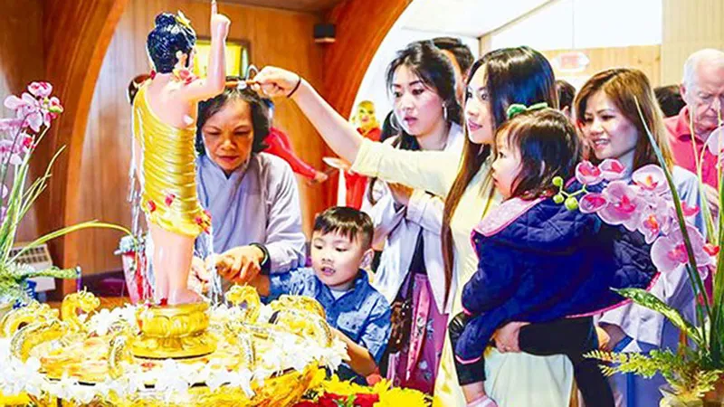 Bà con người Việt tham gia một buổi lễ tắm Phật tại chùa Hội Đức