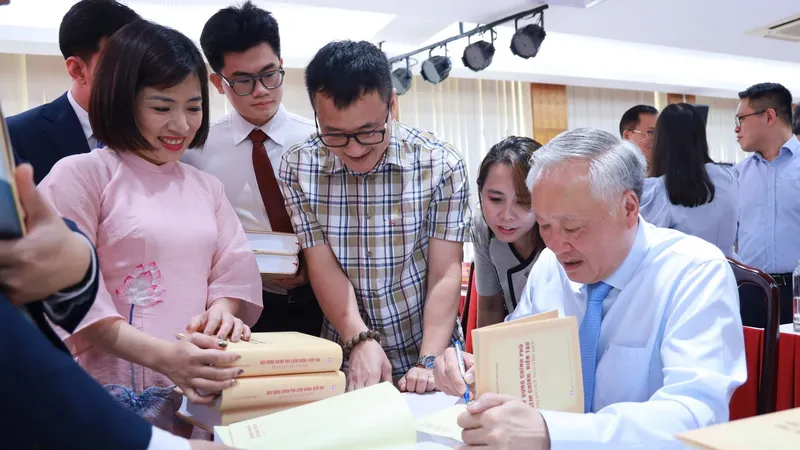 GS-TS Nguyễn Hòa Bình, nguyên Phó Thủ tướng Thường trực Chính phủ ký tặng sách cho bạn đọc. Ảnh: NGUYỄN CHẮT