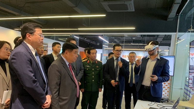 越南副总理阮志勇和其他代表听取了关于人工智能与数字孪生研发中心及卓越中心的报告。图自qdnd.vn