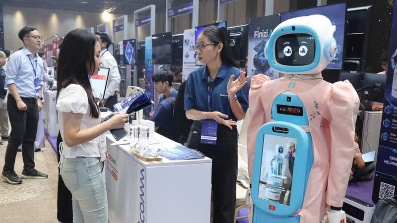 参观者在Qualcomm展台了解老年人护理机器人模型。图自越通社