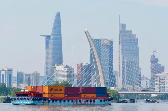 集装箱驳船在西贡河上行驶，途经巴逊桥区域，为胡志明市注入蓬勃的贸易活力。图:黄雄