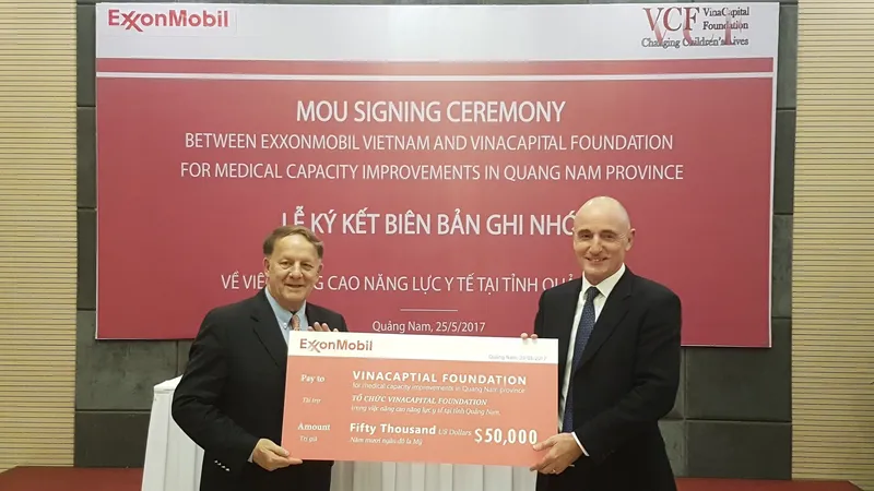 Đại diện lãnh đạo ExxonMobil trao bảng tài trợ cho đại diện Quỹ tài trợ VinaCapital. Ảnh: NGUYÊN KHÔI