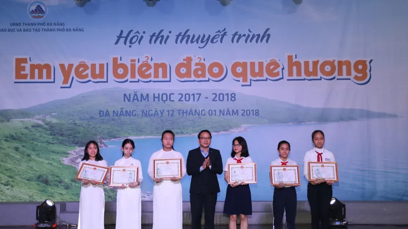Ông Nguyễn Đình Vĩnh, Giám đốc Sở GD-ĐT TP Đà Nẵng trao Giấy khen cho các học sinh đoạt giải nhất cuộc thi “Em viết về Đà Nẵng – Thành phố môi trường”