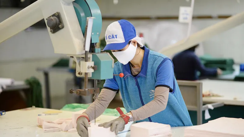 Công nhân tại Công ty Dệt kim Đông Xuân tăng công suất cắt may khẩu trang để đáp ứng nhu cầu mua khẩu trang giá bình ổn của người dân cả nước. Ảnh: Vinatex