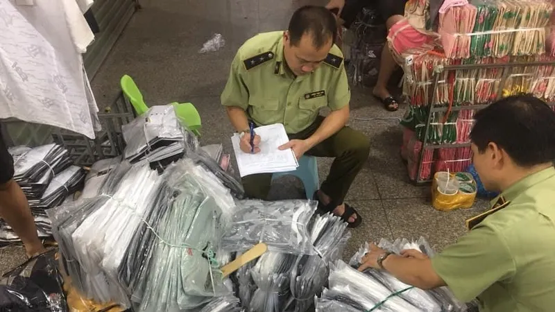 Cán bộ QLTT kiểm kê các lô hàng thời trang nhái, lậu trong chợ Ninh Hiệp hôm 4-6
