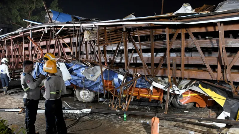  Những chiếc xe bị biển quảng cáo đè bẹp trong trận mưa bão ở Mumbai, Ấn Độ. Ảnh REUTERS