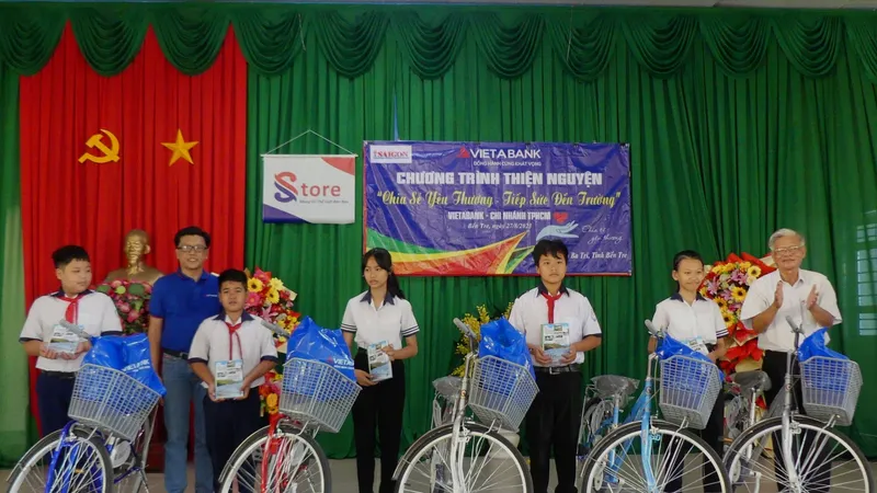 Đại diện Ngân hàng TMCP Việt Á - Chi nhánh TPHCM và Hội Khuyến học huyện Ba Tri trao quà cho học sinh nghèo. Ảnh: KHẢ HÂN