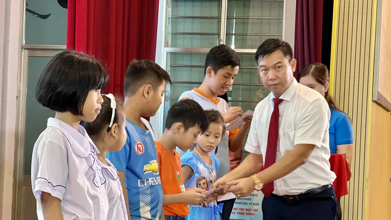 Ông Nguyễn Văn Nhì, Phó Giám đốc Ngân hàng Agribank, chi nhánh KCN Tân Tạo trao học bổng cho các em học sinh. Ảnh: CTV