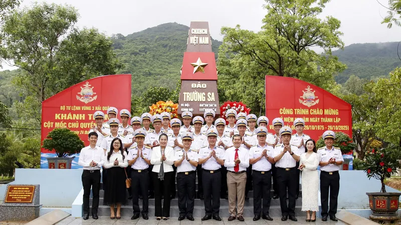 Các đại biểu chụp ảnh lưu niệm bên công trình mô hình cột mốc chủ quyền đảo Trường Sa tại Bộ Tư lệnh Vùng 3 Hải quân