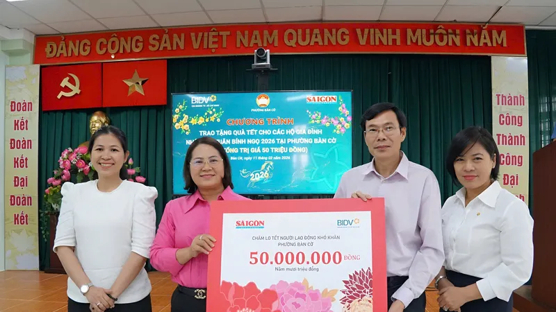 Nhà báo Phạm Văn Trường và bà Bùi Phương Nga trao bảng tượng trưng cho lãnh đạo Ủy ban MTTQ Việt Nam phường Bàn Cờ. Ảnh: VIỆT NGA