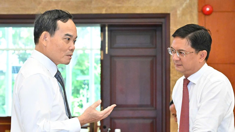 胡志明市市委书记陈留光与胡志明市人委会副主席阮孟强在会议上进行探讨。图:越勇