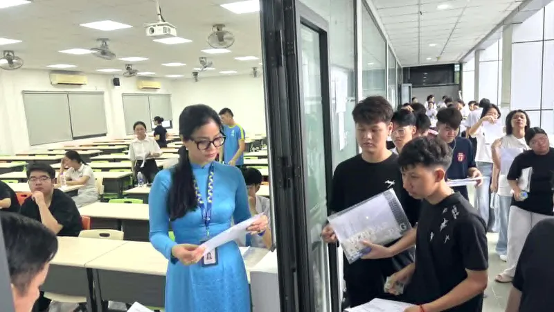 Cán bộ coi thi gọi thí sinh vào phòng thi tại điểm thi Trường ĐH Công nghiệp TPHCM - Ảnh: THANH HÙNG