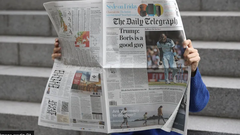 Độc giả xem báo của The Telegraph. Ảnh: JONATHAN BRADY/ PA WIRE 