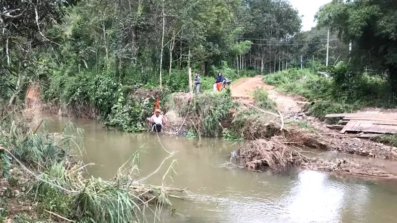 Người dân phải đu dây qua suối.