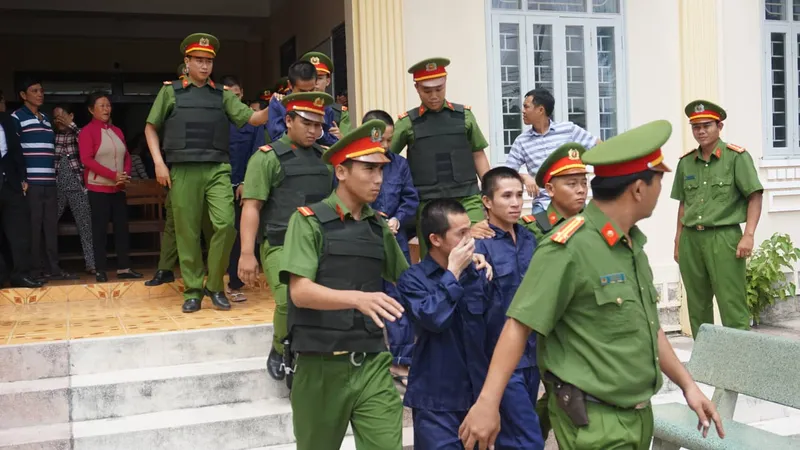 Các bị cáo được dẫn giải ra xe chuyên dụng. 