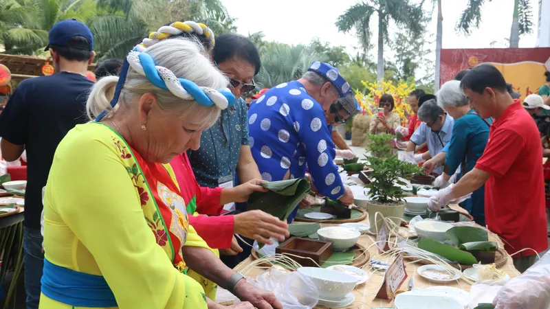 Du khách quốc tế thích thú với hoạt động thi gói bánh chưng.