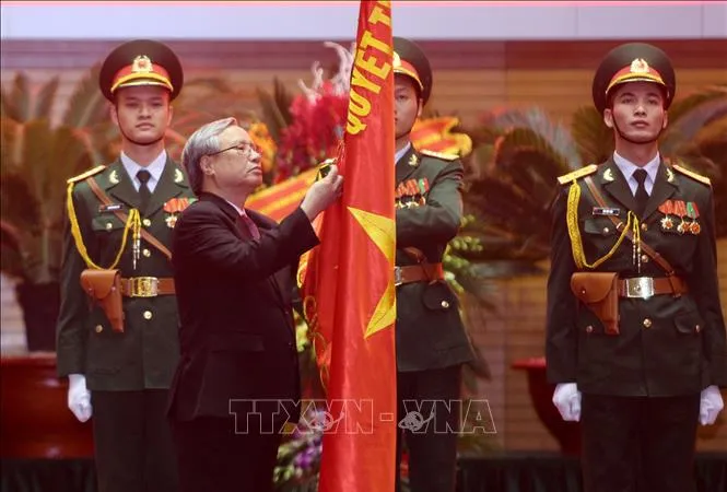Đồng chí Trần Quốc Vượng, Thường trực Ban Bí thư gắn Huân chương Bảo vệ Tổ quốc hạng Nhất lên lá cờ truyền thống của Tổng cục Chính trị QĐND Việt Nam. Ảnh: TTXVN