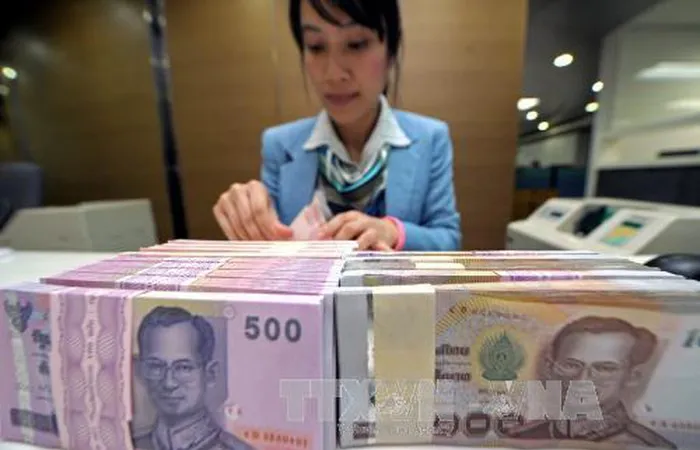 Kiểm tiền baht của Thái Lan tại ngân hàng Krung Thai ở Bangkok. Ảnh: AFP/TTXVN