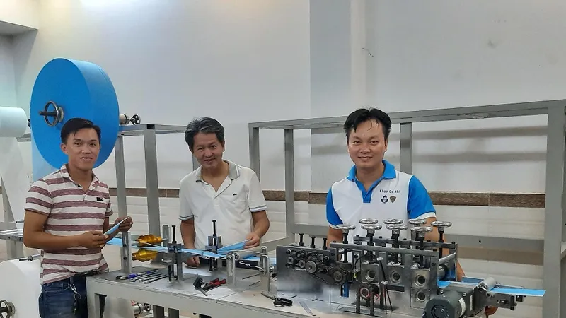 PGS.TS Nguyễn Hữu Lộc (giữa) và TS Nguyễn Thanh Hải (phải) bên máy tạo thân khẩu trang y tế.