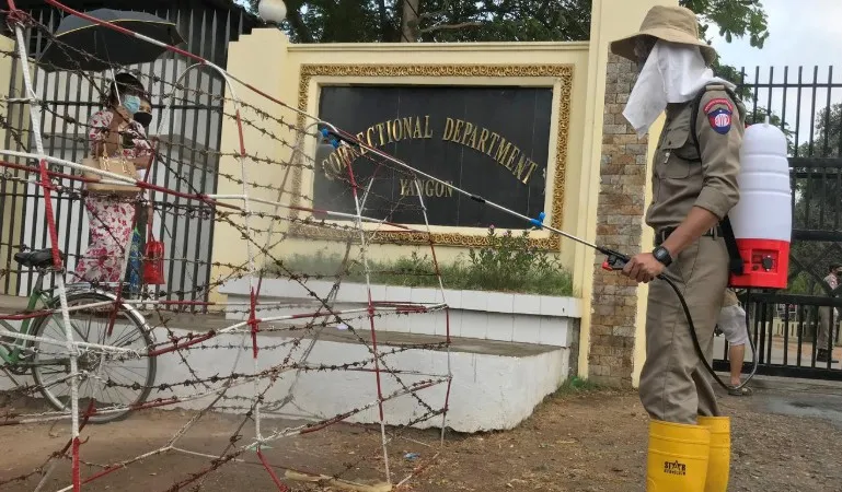 Nhân viên y tế phun khử khuẩn bên ngoài một nhà tù ở Myanmar. Ảnh: Reuters.