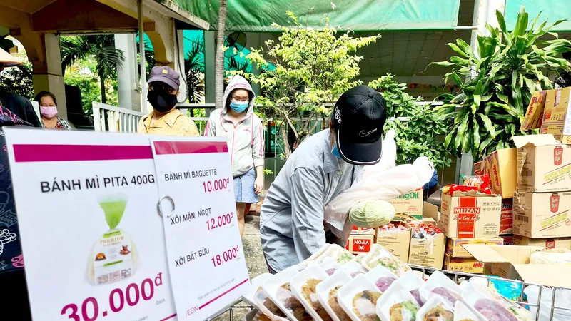 Chọn mua nhu yếu phẩm tại điểm bán dã chiến do Công ty TNHH Aeon Việt Nam tổ chức. Ảnh: NGỌC HIỂN