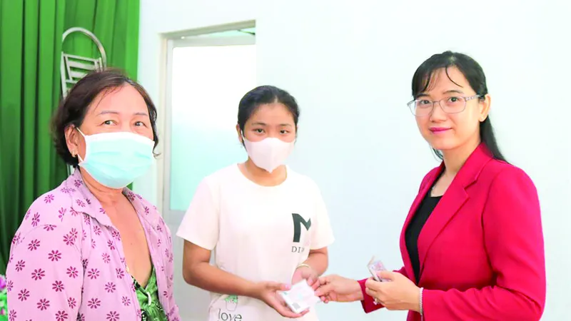 Bà Nguyễn Thị Mỹ Duyên - Phó Trưởng phòng Kế toán Công ty TNHH MTV XSKT Đồng Tháp trao tặng thẻ bảo hiểm y tế cho người dân
