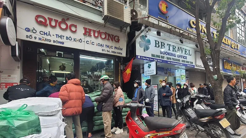 Người dân Hà Nội kiên nhẫn xếp hàng để mua bánh chưng, giò chả tết 