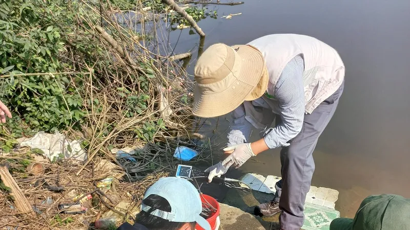 Lấy mẫu nước tại khu vực xảy ra tình trạng cá chết trên sông Ô Giang