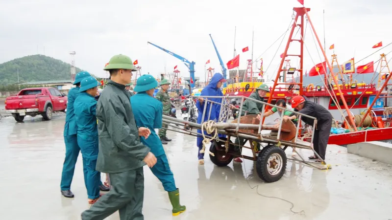 Cán bộ, chiến sĩ, bộ đội biên phòng, dân quân tự vệ Bộ CHQS tỉnh Nghệ An hướng dẫn và giúp ngư dân neo đậu tàu thuyền