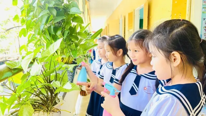 Học sinh Trường Tiểu học Lê Lợi (TP Huế) tưới cây ở các hành lang lớp học