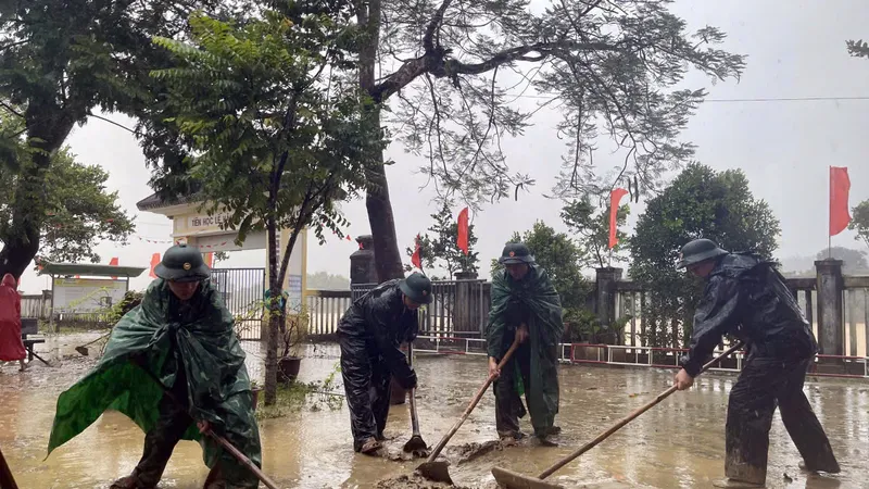 Bộ đội Biên phòng hỗ trợ Trường THCS Hương Thọ (TP Huế) thu dọn bùn non ứ đọng tại sân trường khi lũ rút