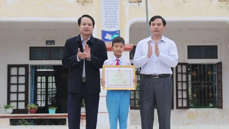 Trao bằng khen của Bộ trưởng Bộ GD-ĐT cho em Võ Hồng Hiếu. Nguồn ảnh: Phòng GD -ĐT huyện Lộc Hà