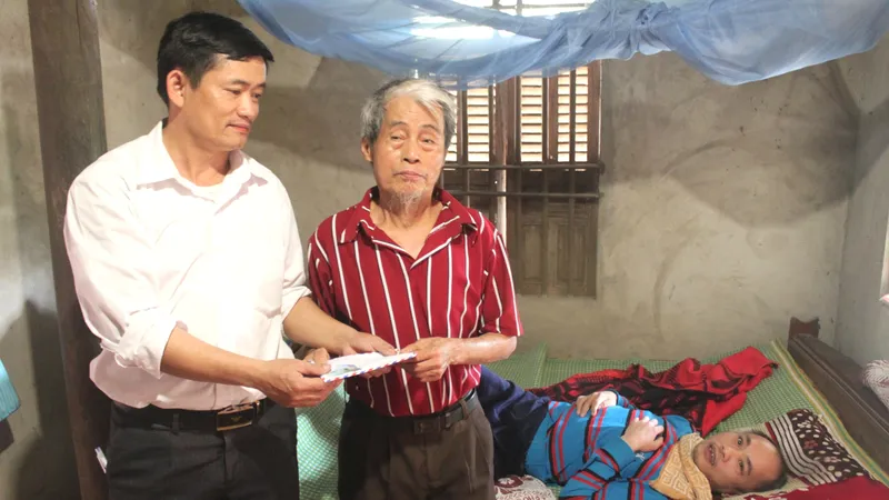 Đại diện UBND xã Đức Bồng, huyện Vũ Quang trao 12 triệu đồng của bạn đọc Báo SGGP cho gia đình anh Trần Sinh Nhật