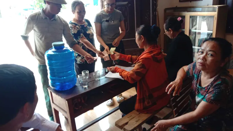 Người dân đến nhà văn hóa thôn Thượng Tứ góp tiền ủng hộ em Bùi Đình Thắng