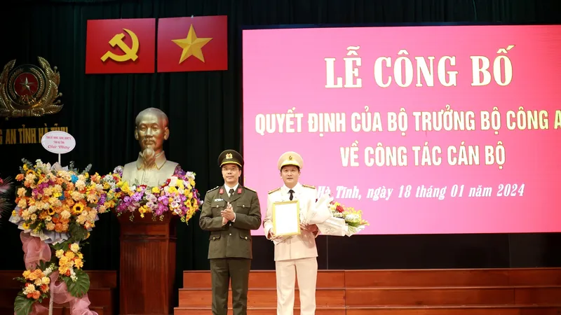 Đại tá Nguyễn Hồng Phong, Giám đốc Công an tỉnh Hà Tĩnh trao quyết định và tặng hoa chúc mừng Trung tá Nguyễn Quốc Hùng