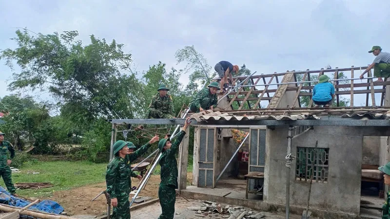 Các cán bộ, chiến sĩ Đồn Biên phòng Thiên Cầm giúp người dân sửa lại nhà cửa do lốc xoáy gây ra 