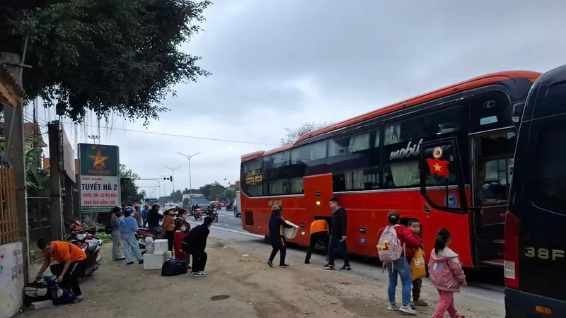 Người dân Hà Tĩnh chờ bên quốc lộ 1A để đón xe khách ra Bắc, vào Nam sau tết 