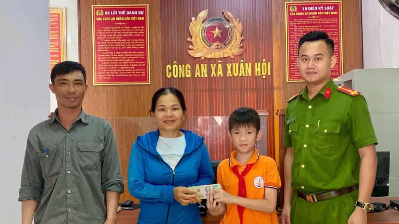Tại trụ sở Công an xã Xuân Hội, em Hoàng Đức Duy trao trả lại số tiền cho người đánh rơi 